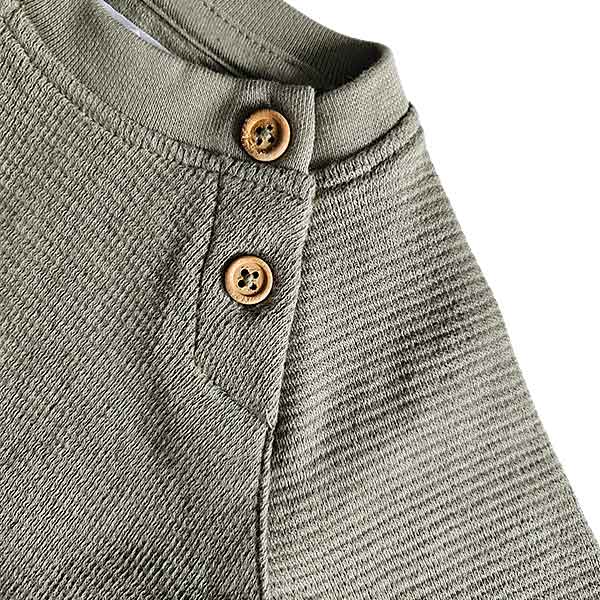 Studio Spruitje tweedehands babyshirt groen met houten knoopjes en lange mouwen.