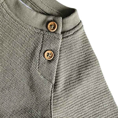 Studio Spruitje tweedehands babyshirt groen met houten knoopjes en lange mouwen.